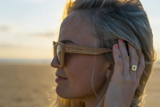 Woman wearing sunglasses with a blurred beach background