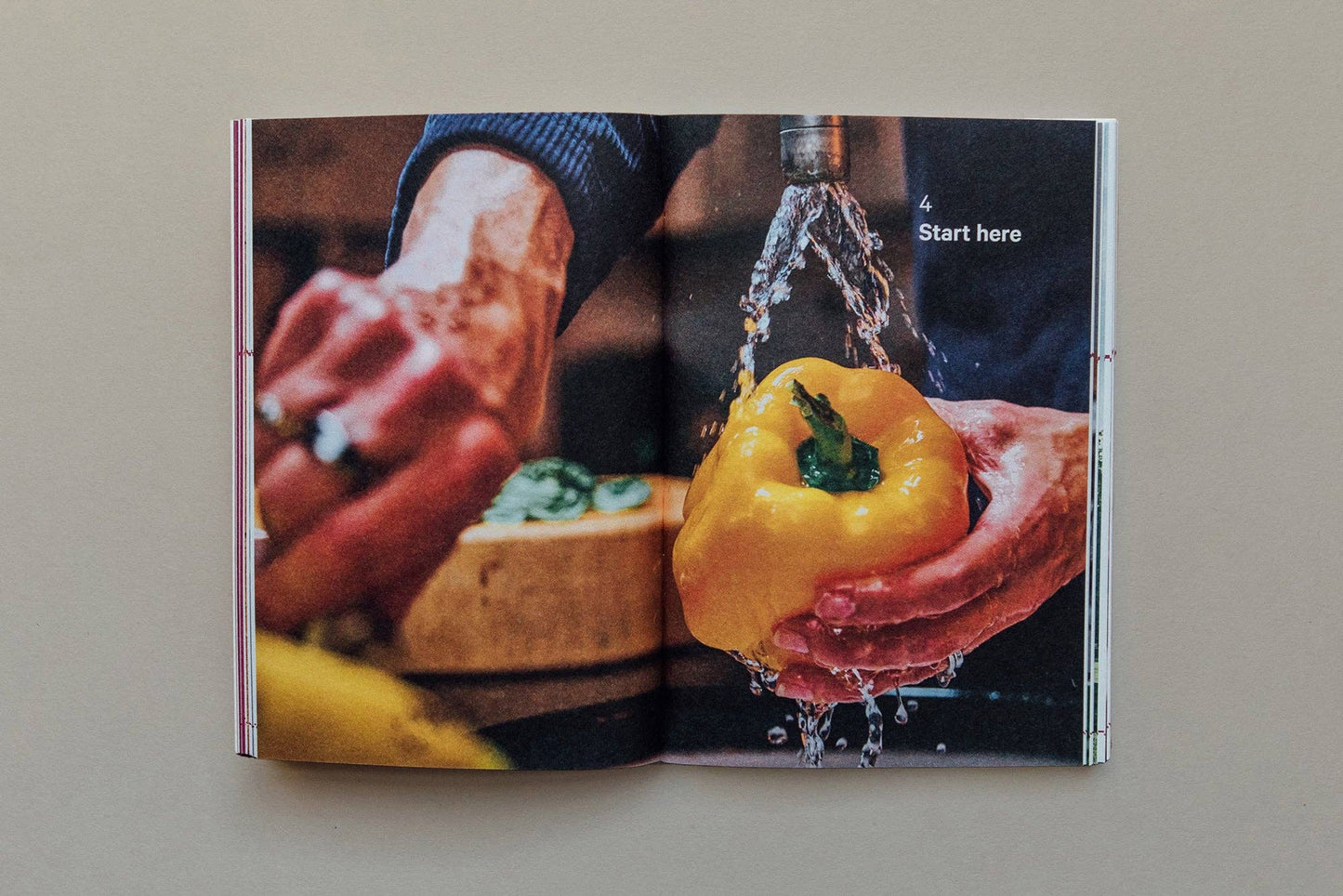 Open book showing a person washing a yellow bell pepper with water.