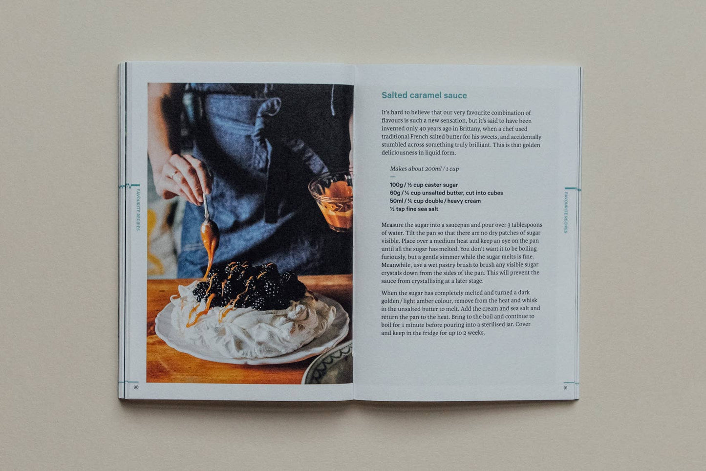 Open cookbook showing a recipe for salted caramel sauce with a person pouring it over dessert.