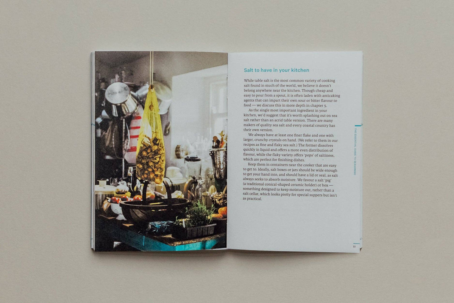 Open book showing a kitchen interior with text on a neutral background