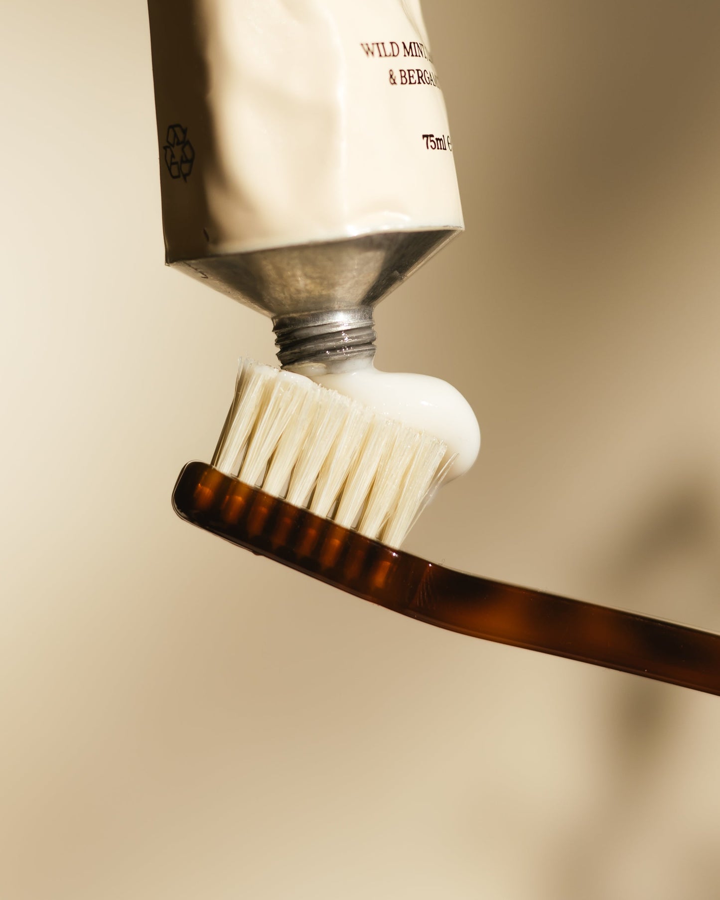 Naturally Whitening Toothpaste being squeezed onto a toothbrush ready for use.