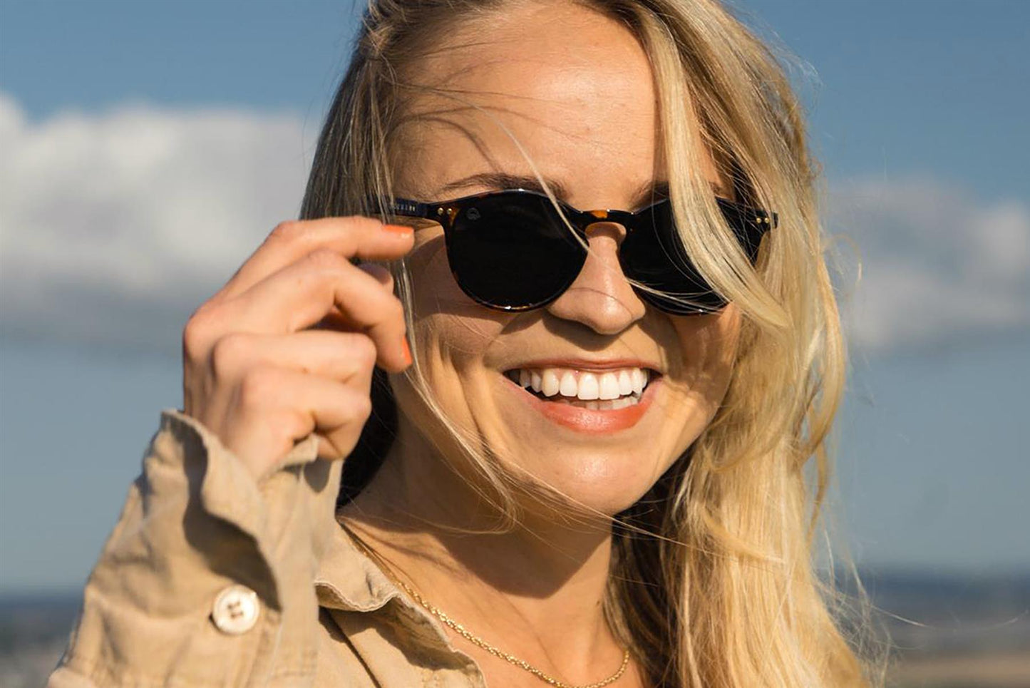 Woman wearing sunglasses with a scenic background
