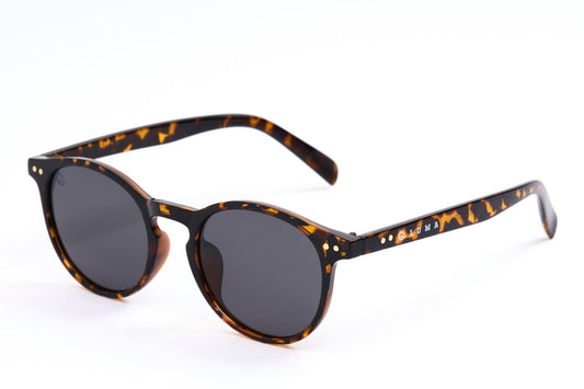 Sunglasses with tortoiseshell frame and dark lenses on a white background