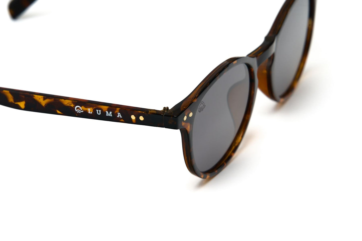 Sunglasses with tortoiseshell frame and dark lenses on a white background