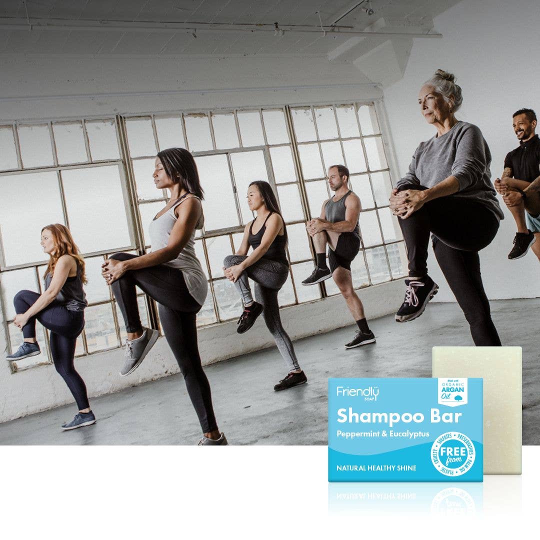 Group of people exercising in a studio with a Friendly Shampoo Bar displayed.