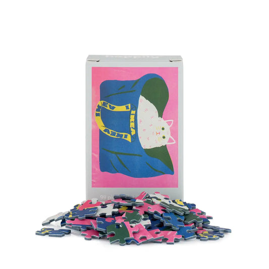Puzzle box with a cat illustration on a pink background, surrounded by puzzle pieces.
