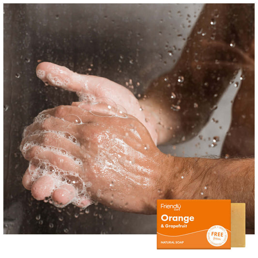 Person washing hands with soap, displaying a bar of Friendly Soap in the corner.
