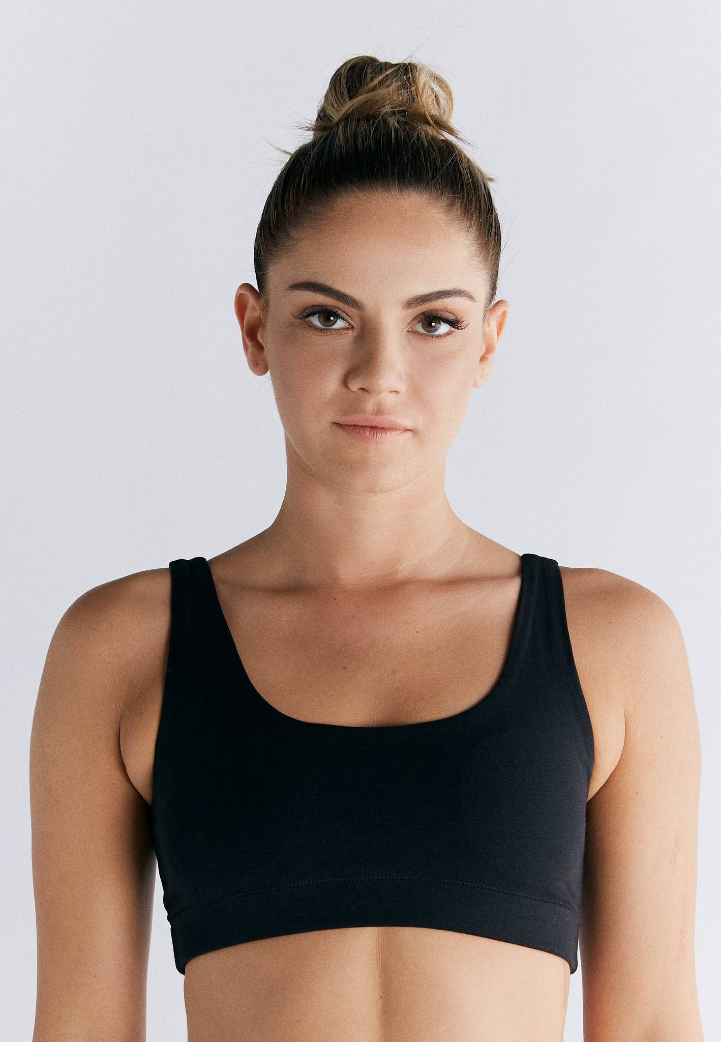 Model wearing Organic Cotton Padded Bralette in black, showcasing its soft structure and supportive design.
