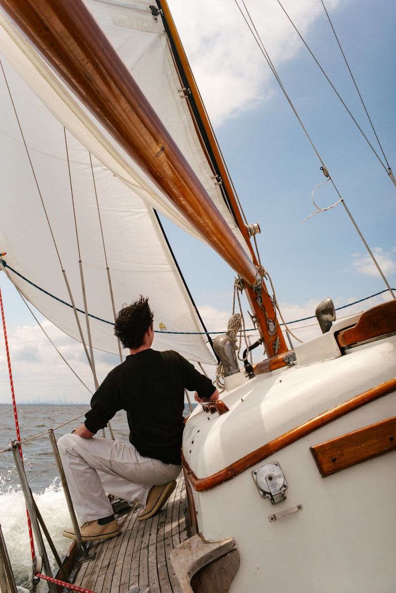 Person on a sailboat with a clear sky and water background