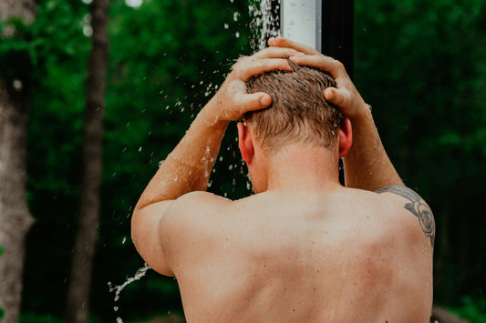 Greywater, Green Future: Why Reusing Household Water Is No Longer Optional – man showering outdoors, emphasizing water reuse.