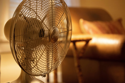 Image of a vintage table fan providing cool air in a cozy living room setting.