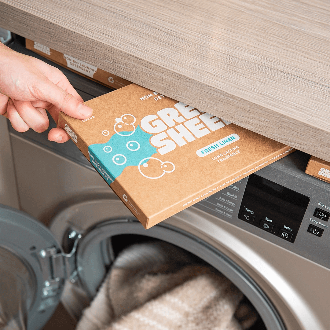 The Rise of Natural Laundry Detergents: A Greener Way to Clean - person placing Green Sheet detergent box in washing machine.