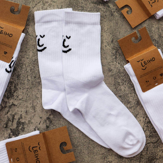 White Organic Cotton Smiley Socks by Leiho, GOTS-certified eco-friendly gift UK with bold yellow smiley face design from ALEWK.CLUB