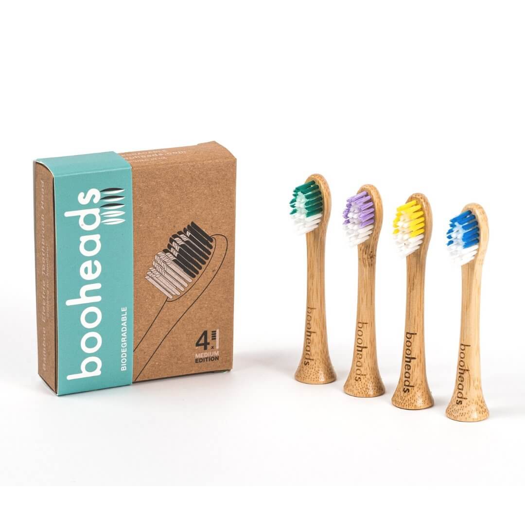Set of bamboo toothbrushes with colorful bristles and packaging on a white background
