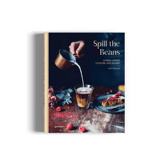 Book titled 'Spill the Beans' with a person pouring milk into a glass on a wooden table.