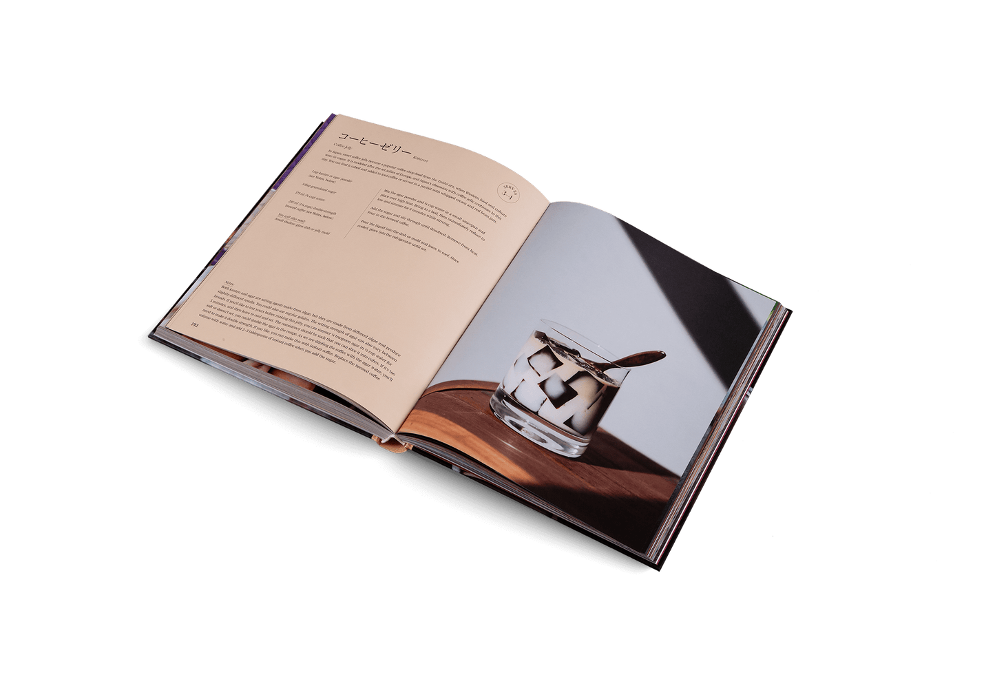 Open book showing a photograph of a glass on a wooden surface with a white background