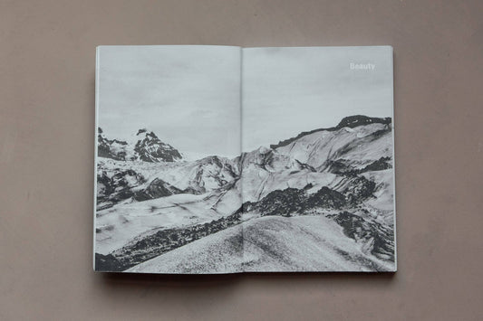 Open book with black and white landscape illustration on a brown background