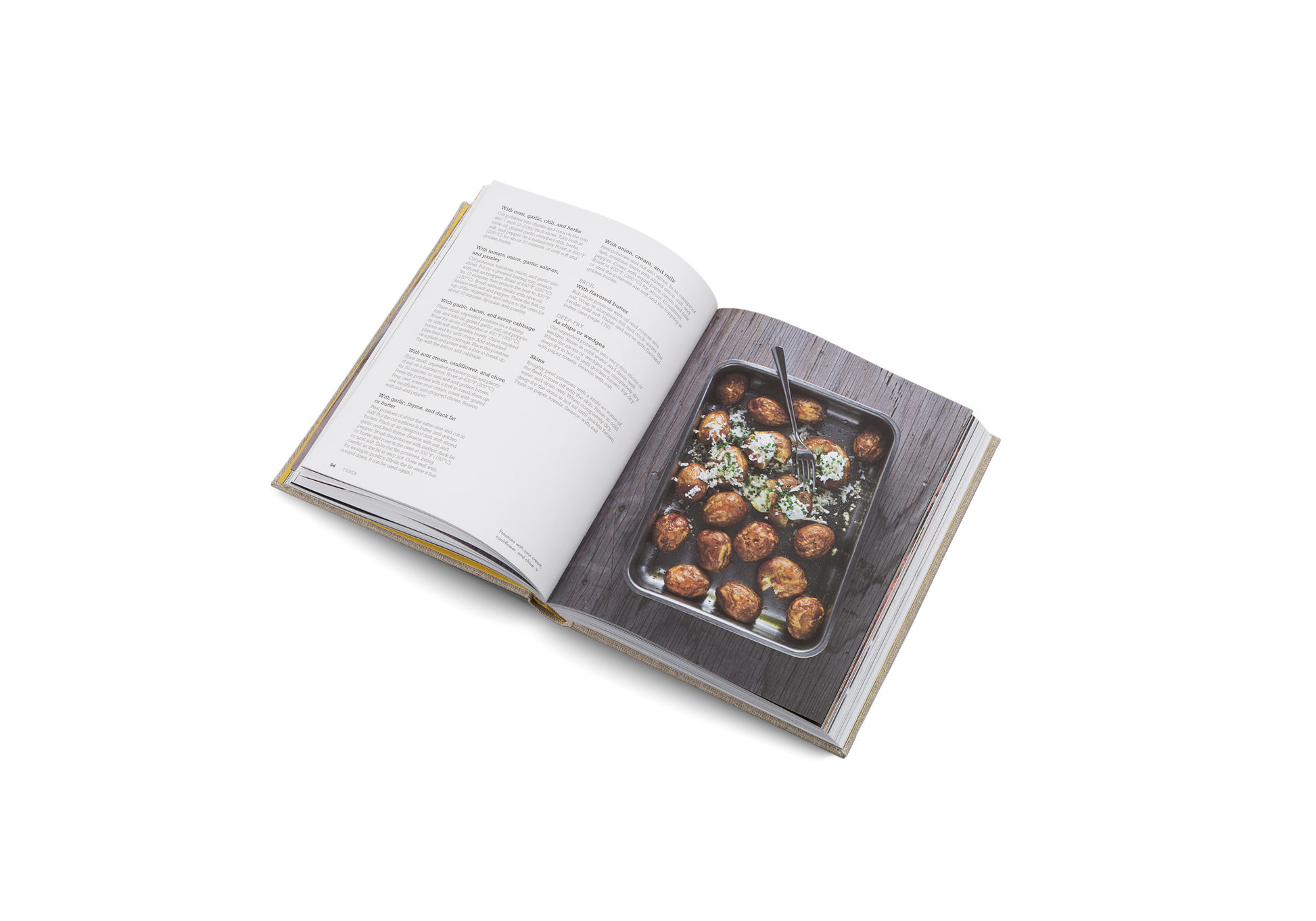 Open cookbook showing a page with a photograph of roasted vegetables on a white background