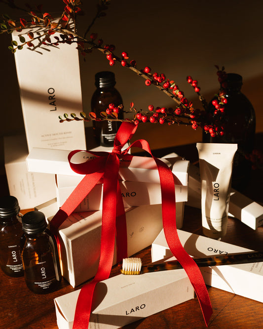 Naturally Whitening Toothpaste and other LARO products beautifully packaged with red ribbon and decorations.