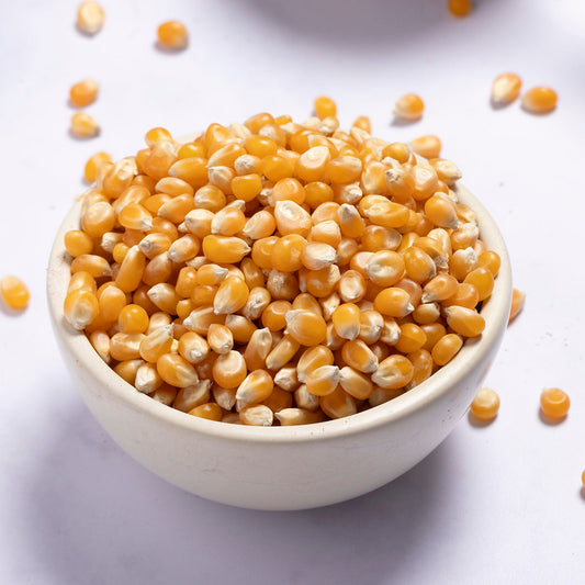White bowl filled with yellow corn kernels on a white background