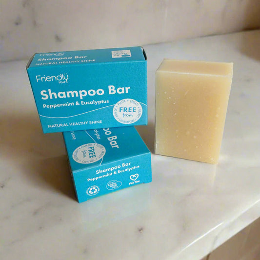 Two boxes of Friendly Soap Shampoo Bar with a bar of soap on a white background