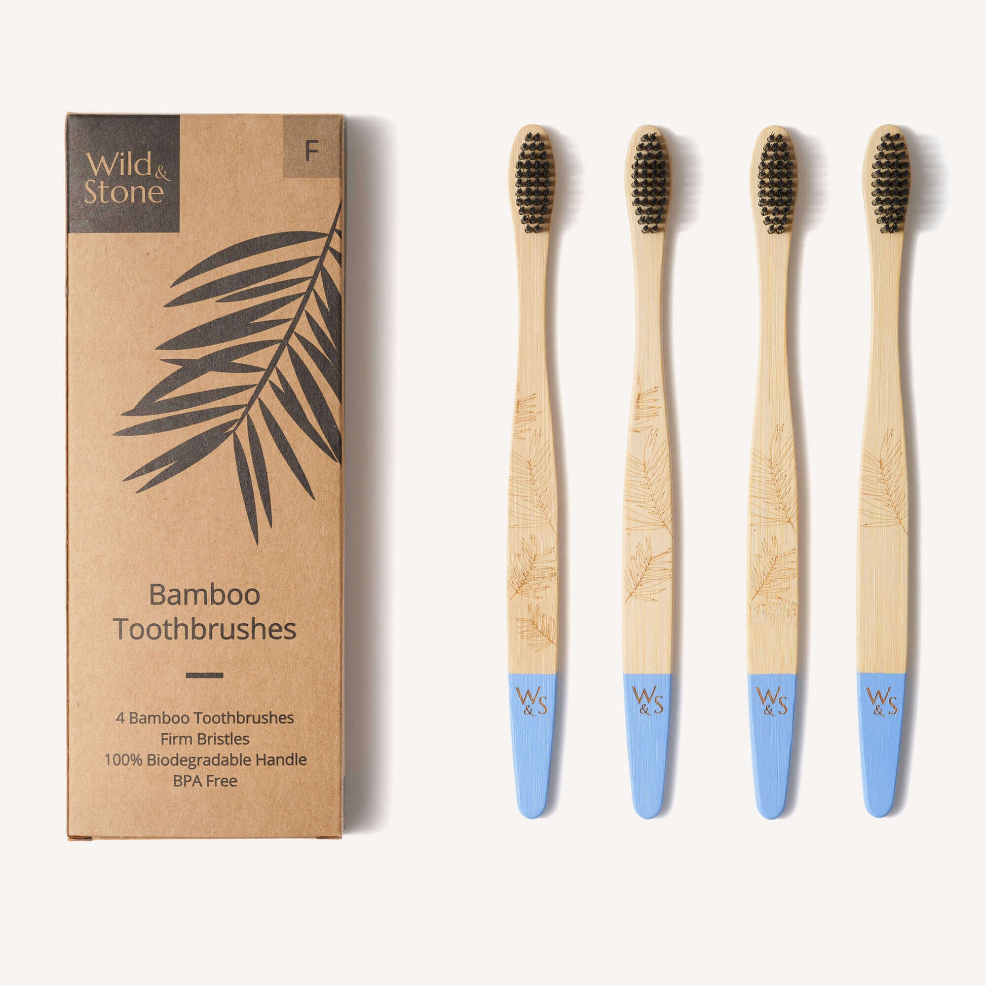 Set of four bamboo toothbrushes with blue handles next to their packaging box on a white background.