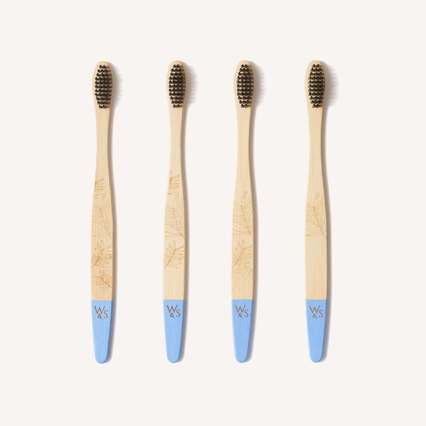 Four bamboo toothbrushes with blue handles on a white background