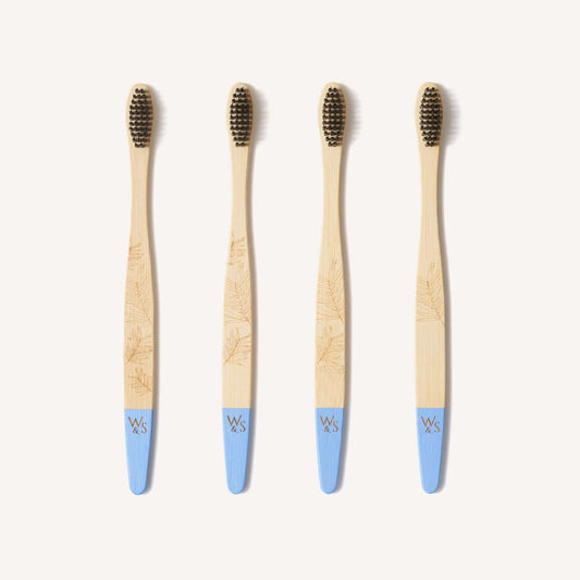 Four bamboo toothbrushes with blue handles on a white background