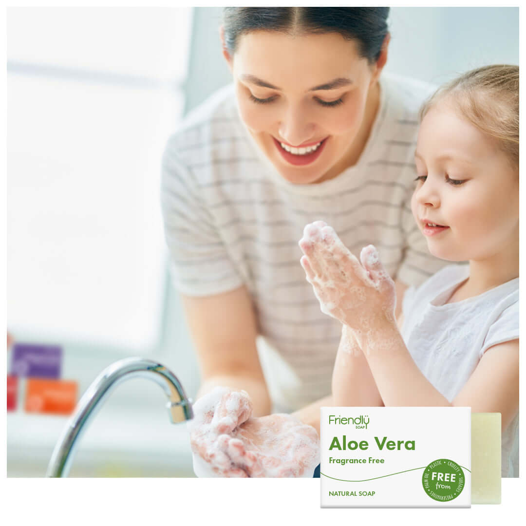 Woman and child washing hands with a box of Friendly Soap in the foreground