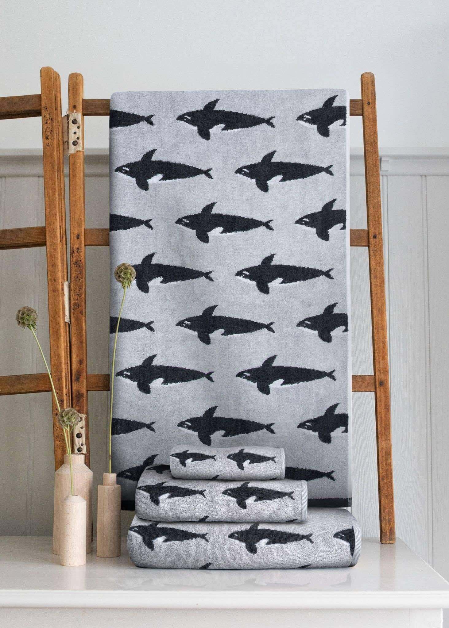 Gray towel with black shark pattern on a wooden rack