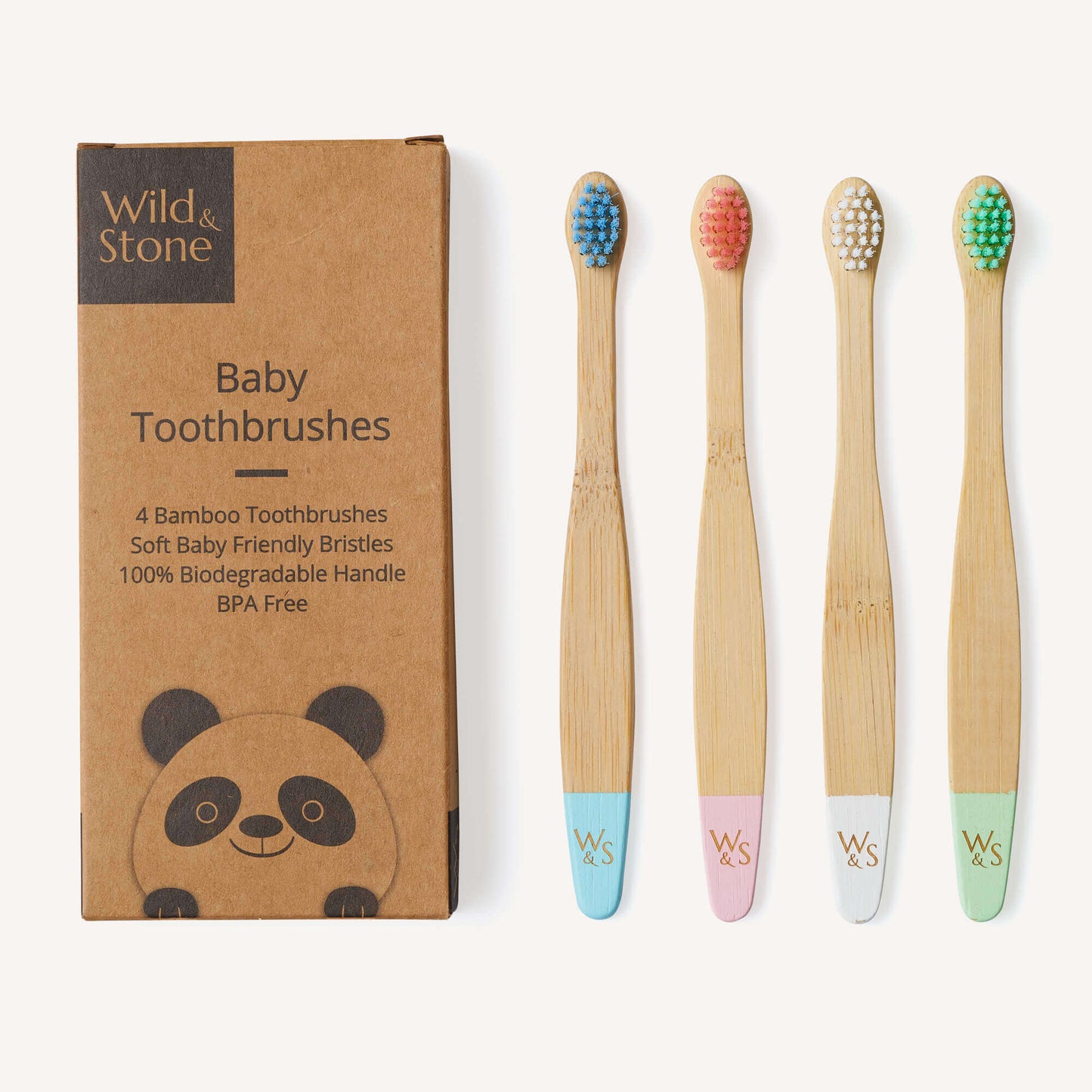 Set of four bamboo baby toothbrushes with colored bristles and packaging by Wild & Stone.