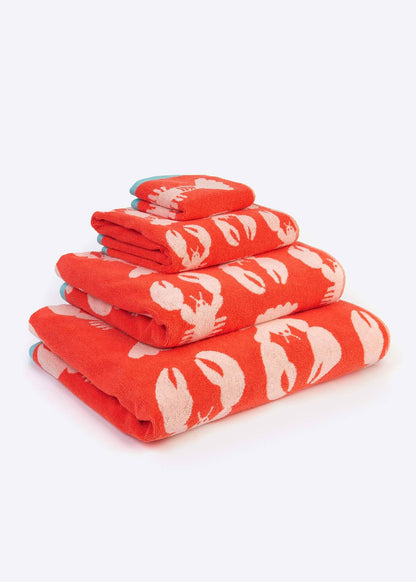 Folded stack of Anorak organic cotton towels in a red and white lobster print