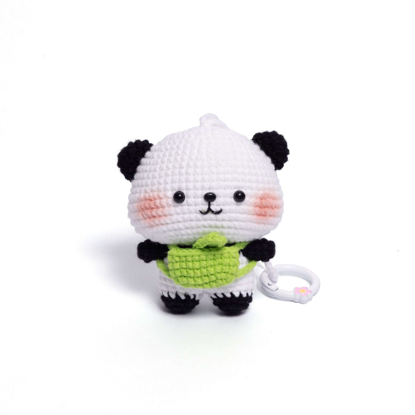 Crocheted panda toy with a green bow tie on a white background