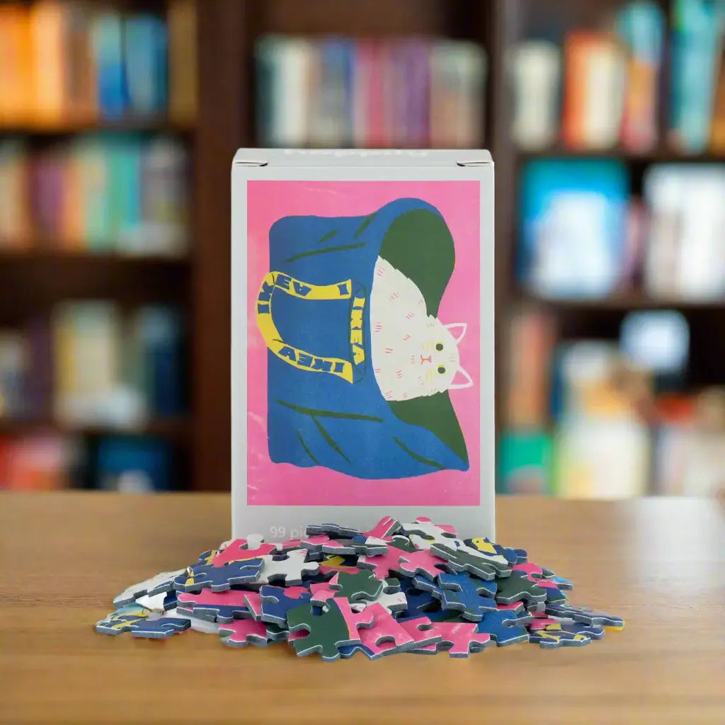 Puzzle box with a cat illustration on a pink background, surrounded by puzzle pieces.