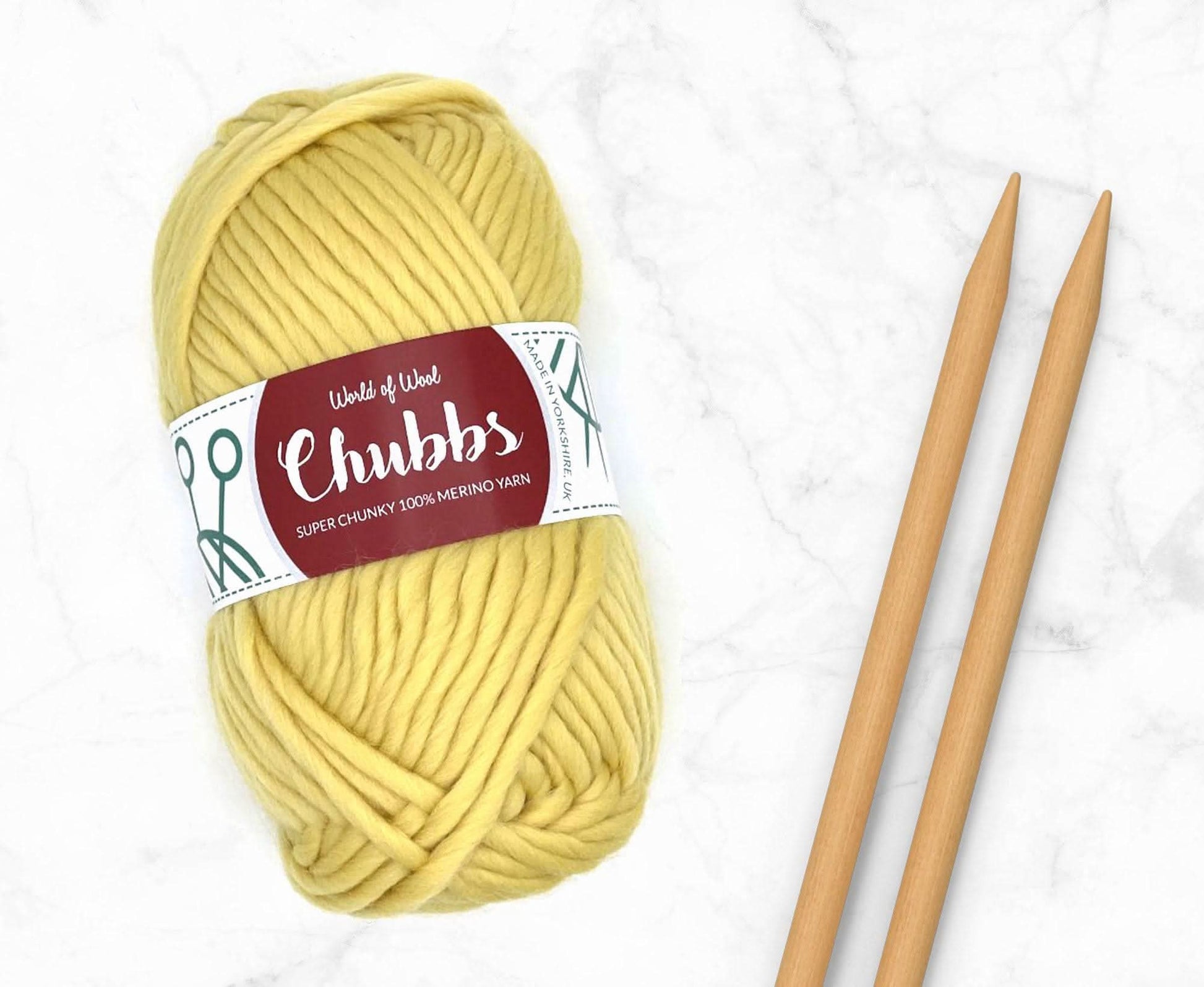 Catkin Merino Super Chunky Weight yarn in yellow with knitting needles, soft and ideal for chunky projects.