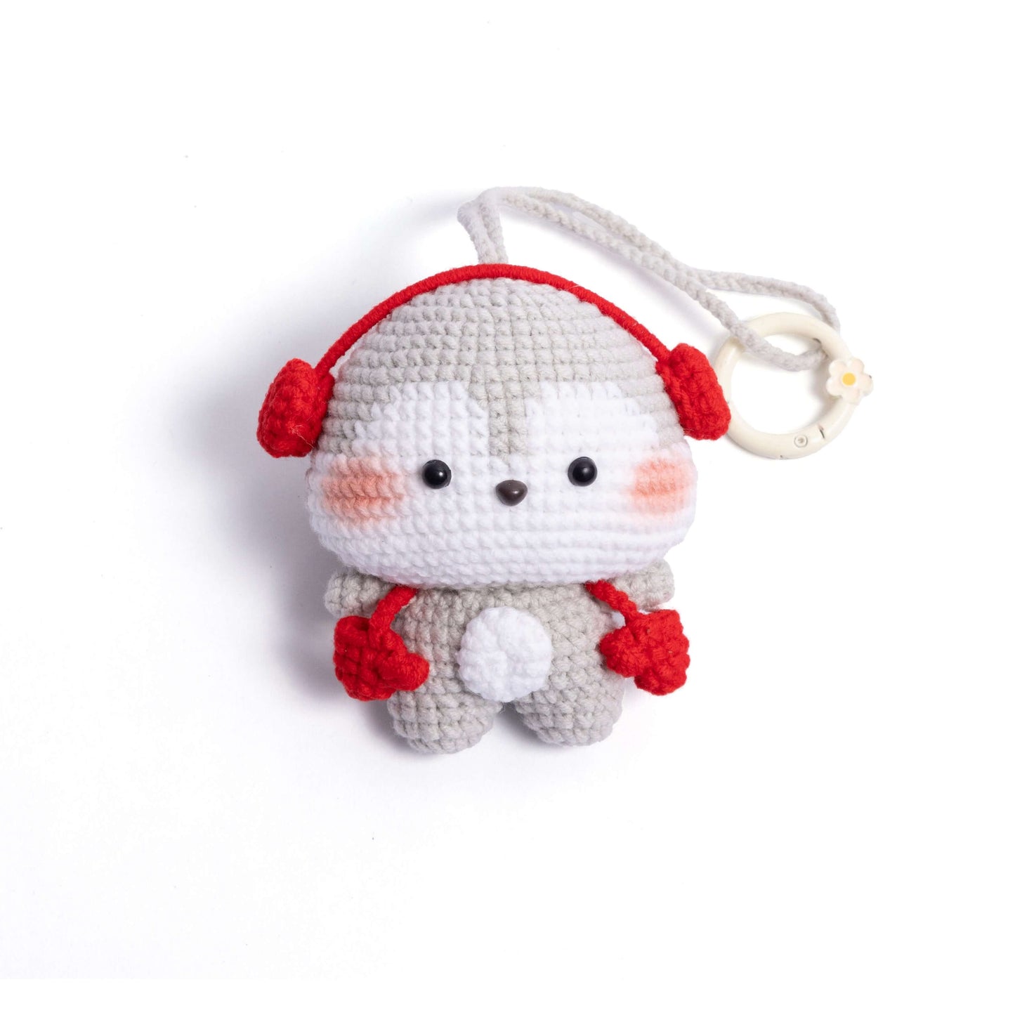 Crocheted character with red headphones on a white background