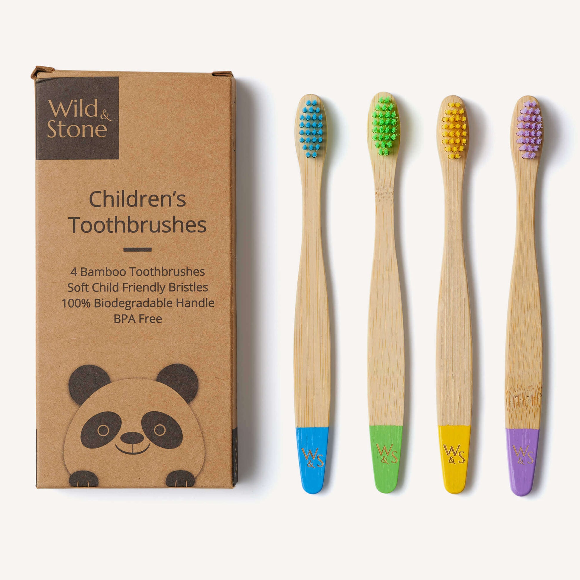 Set of four children's bamboo toothbrushes with colored bristle heads next to their packaging.