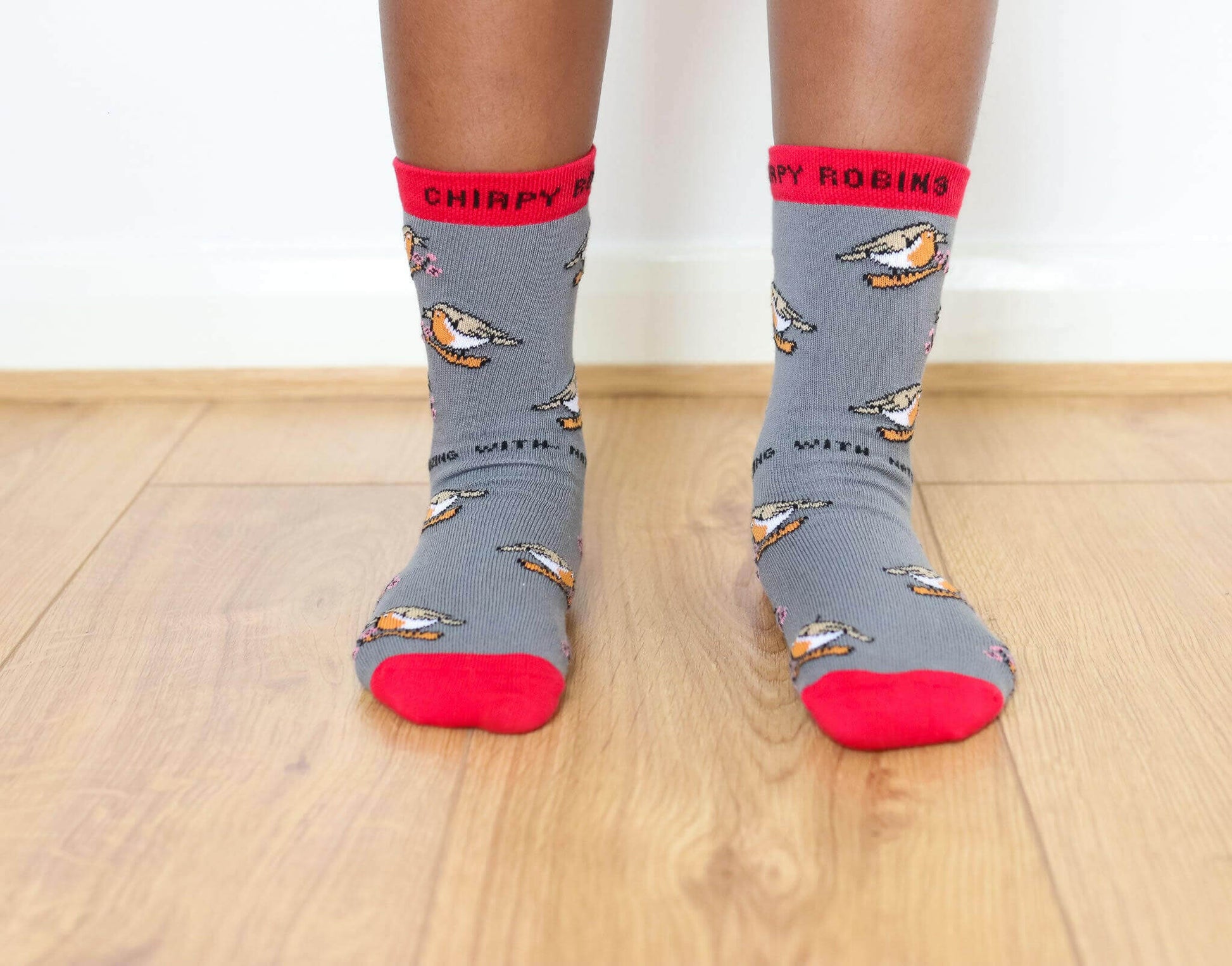 CHIRPY ROBIN ORGANIC COTTON KIDS SOCKS displayed on a child's feet, showcasing playful design in grey and red.