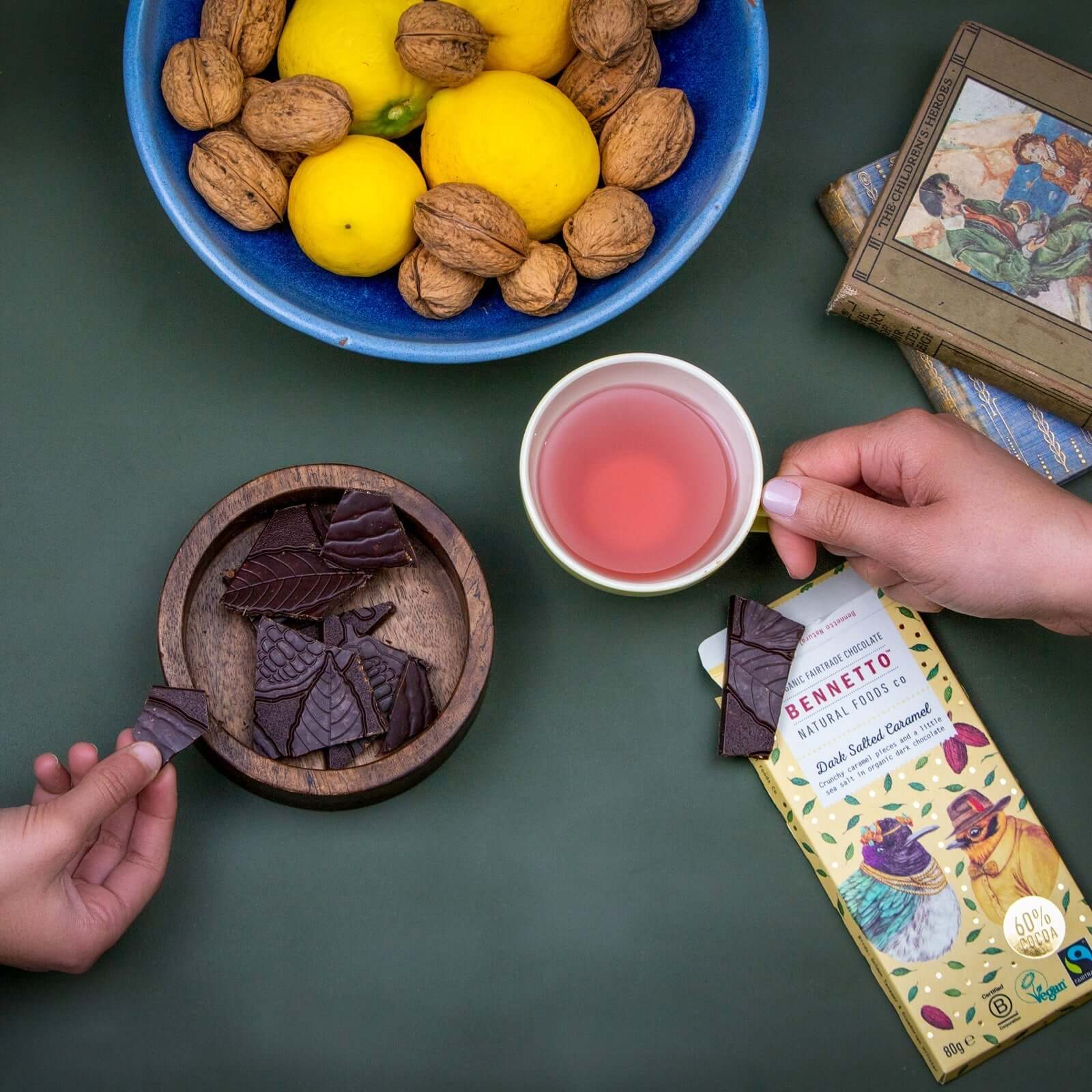 Dark Salted Caramel chocolate pieces served with tea and fresh fruits on a table.