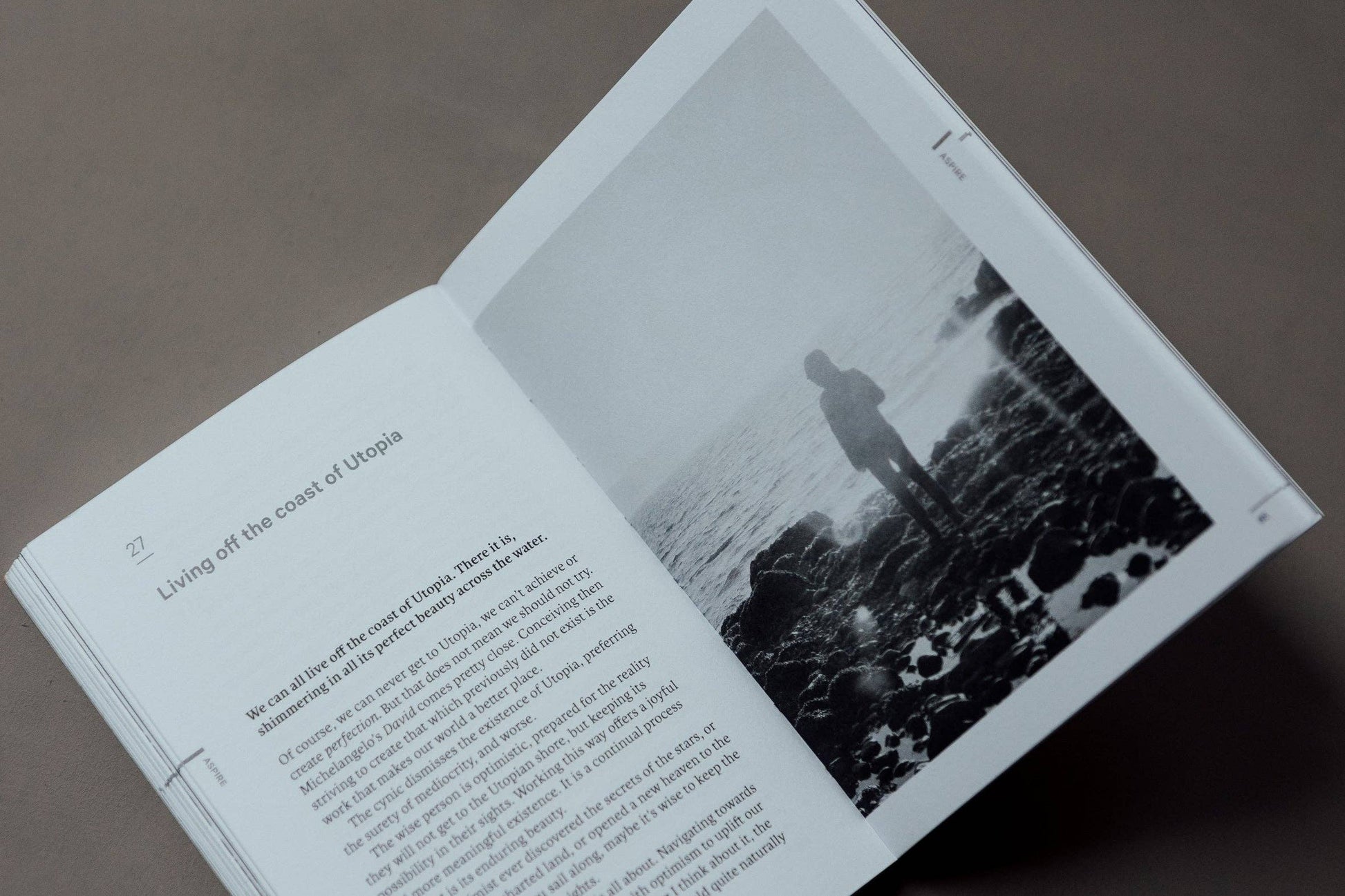 Open book with text and a black and white photograph of a person on a beach.