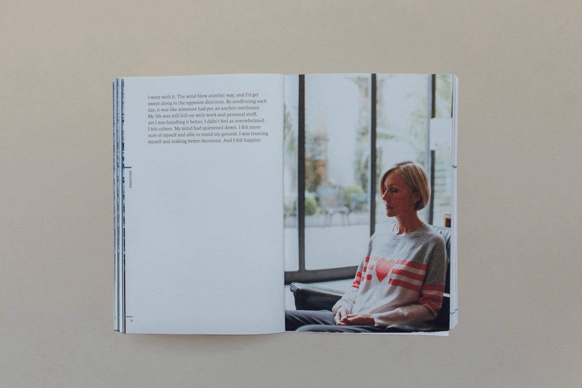 Open book showing a page with text and an image of a person sitting by a window.