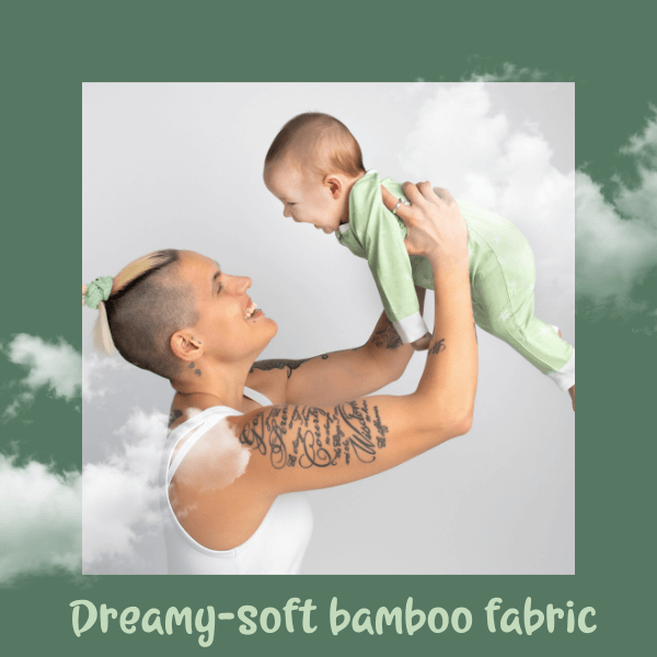 Person holding a baby wearing a green outfit with a cloud background and text 'Dreamy-soft bamboo fabric'.