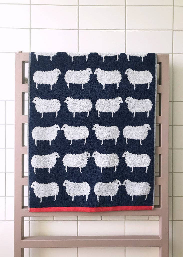 Bundle Hand Towel & Face Cloth - Kissing Sheep print displayed on a rack with a charming sheep design.