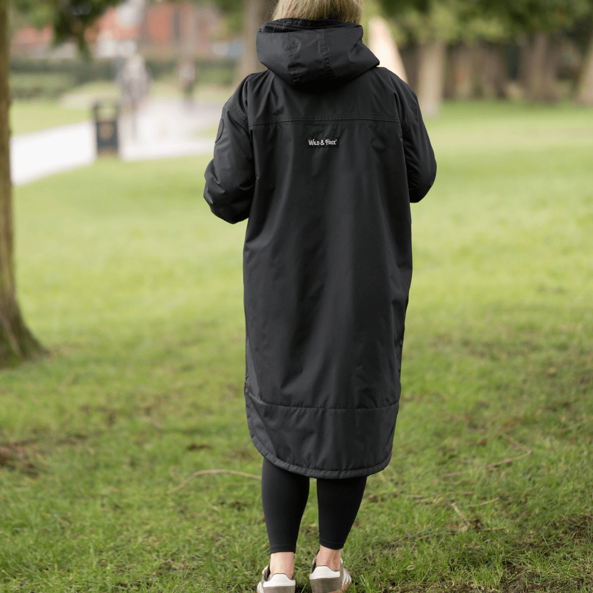 Raincoat & Changing Robe in One - The Classic Cobe Black worn outdoors, showcasing eco-friendly design and versatility.