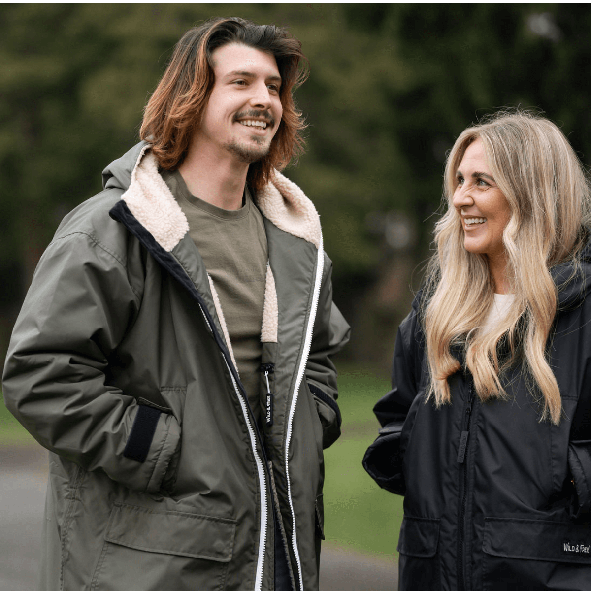 Raincoat & Changing Robe in One - The Classic Cobe Olive Green worn by a man and woman outdoors.