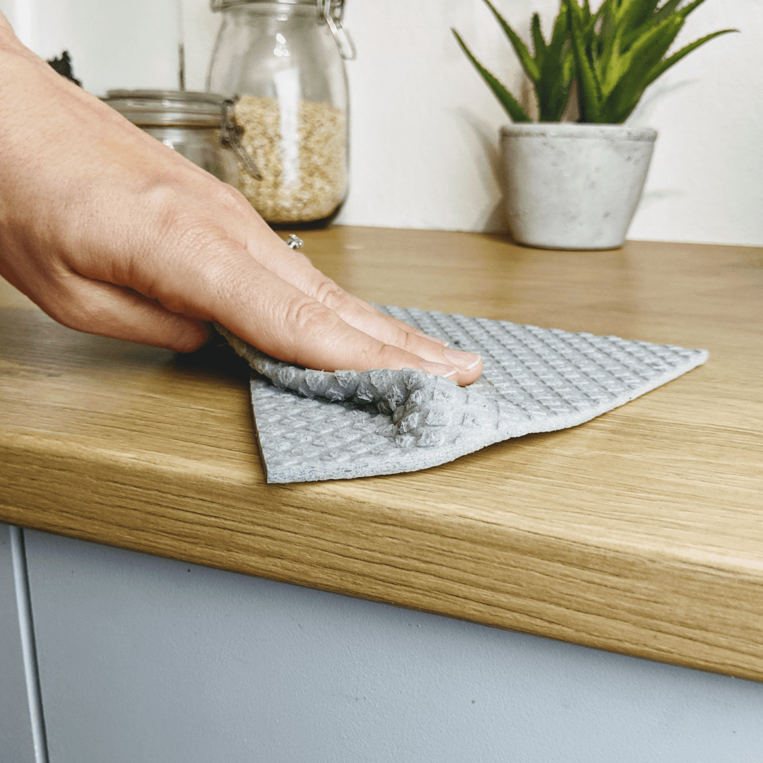 Person using All-Purpose Eco Cloths (Swedish Dishcloths) | 6 Pack to clean a wooden countertop.