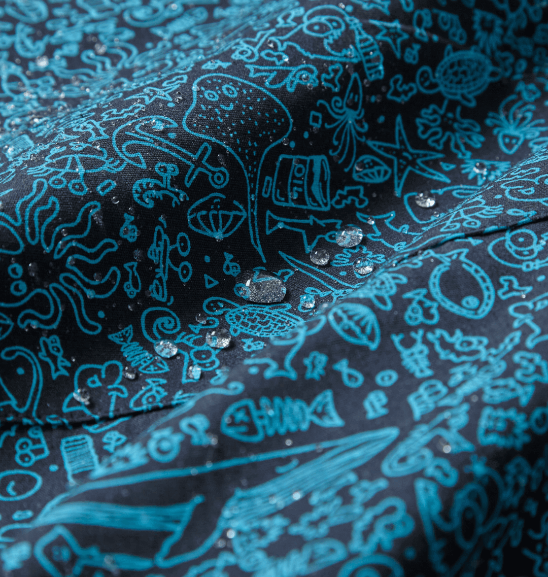 Close-up of water-repellent fabric featuring a marine-inspired print with droplets, perfect for eco-friendly rain ponchos.