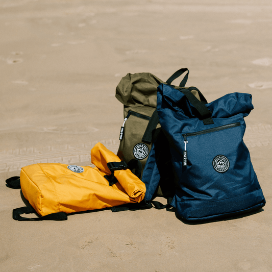 The Backpack in three colors: orange, green, and navy, perfect for adventures, available at Alewk.club.