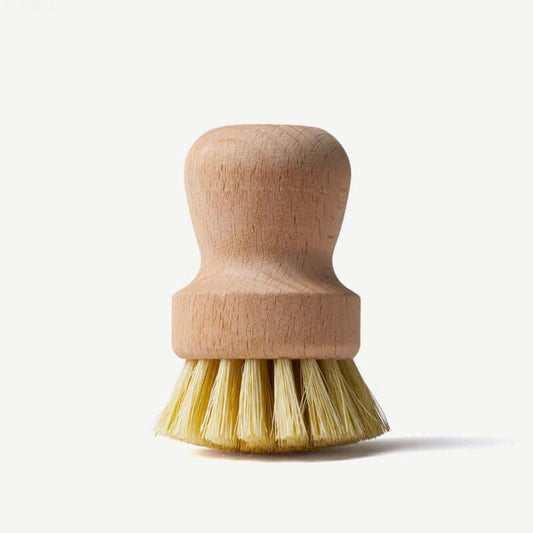 Wooden dish brush with yellow bristles on a white background