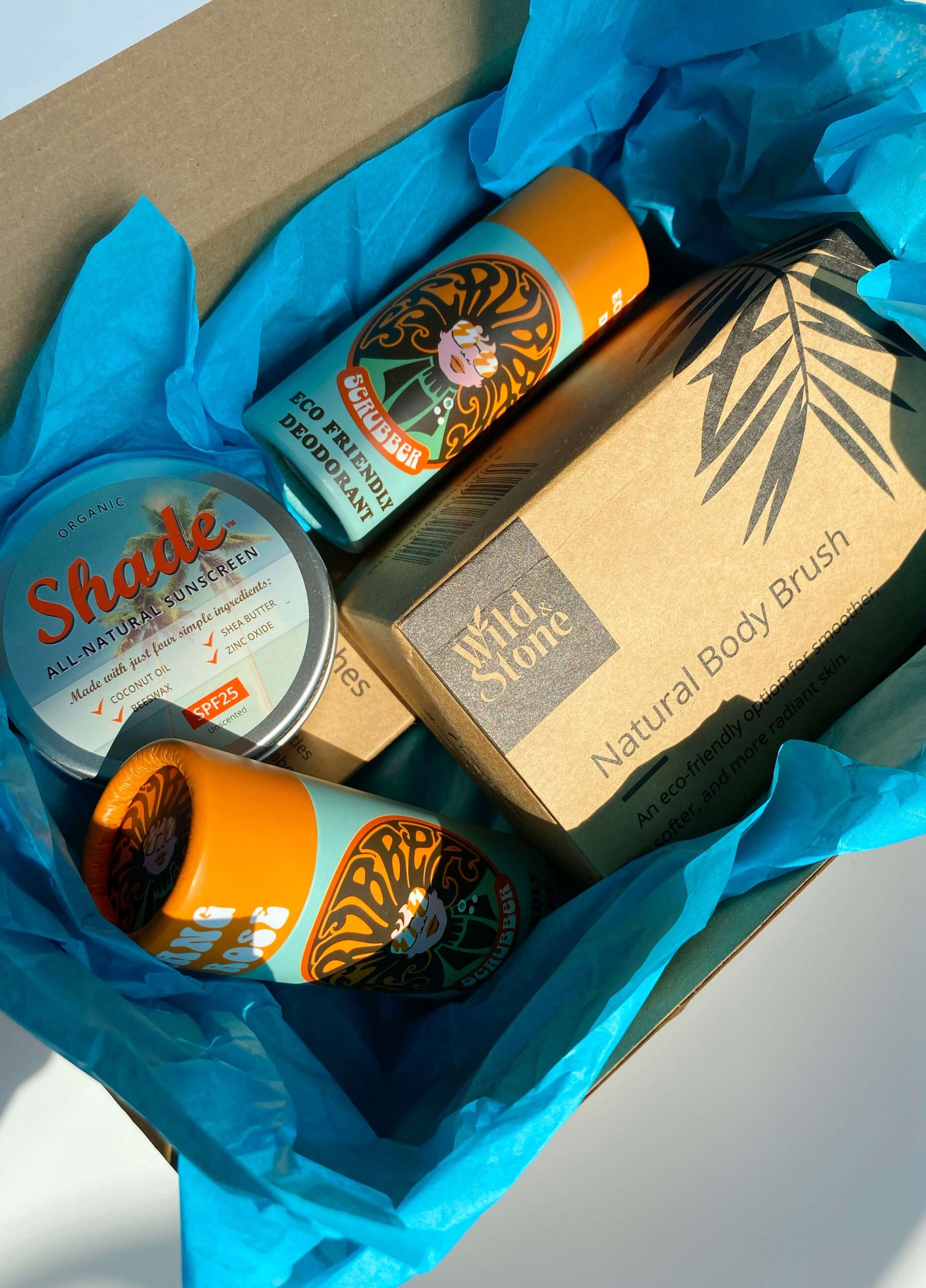 Eco Essentials Home Gift Set featuring bamboo toothbrushes, natural body brush, Ylang & Rose soap bars, and Shade all-natural sunscreen, arranged on a neutral background for a minimalist, sustainable lifestyle look